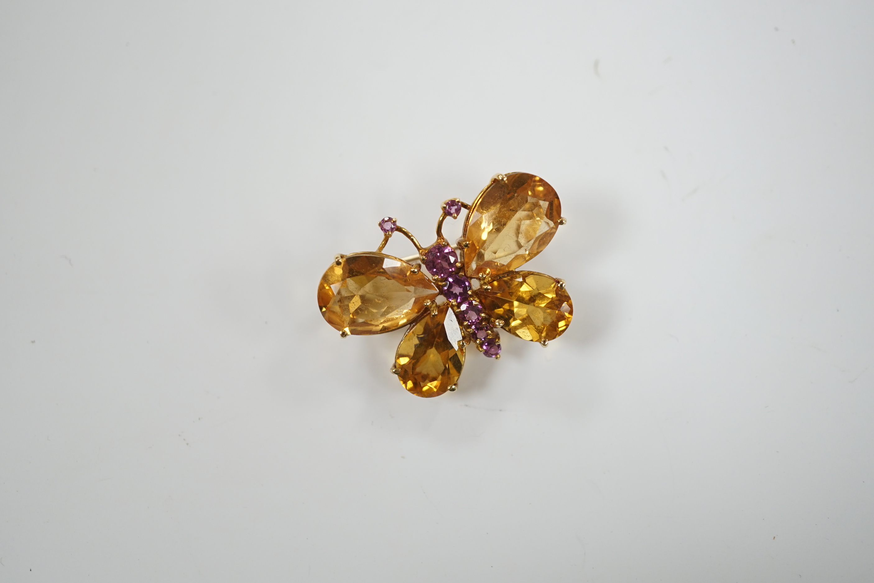 A modern Italian 750 yellow metal, four stone citrine and graduated seven stone pink sapphire set butterfly brooch, width 32mm, gross weight 8.1 grams.